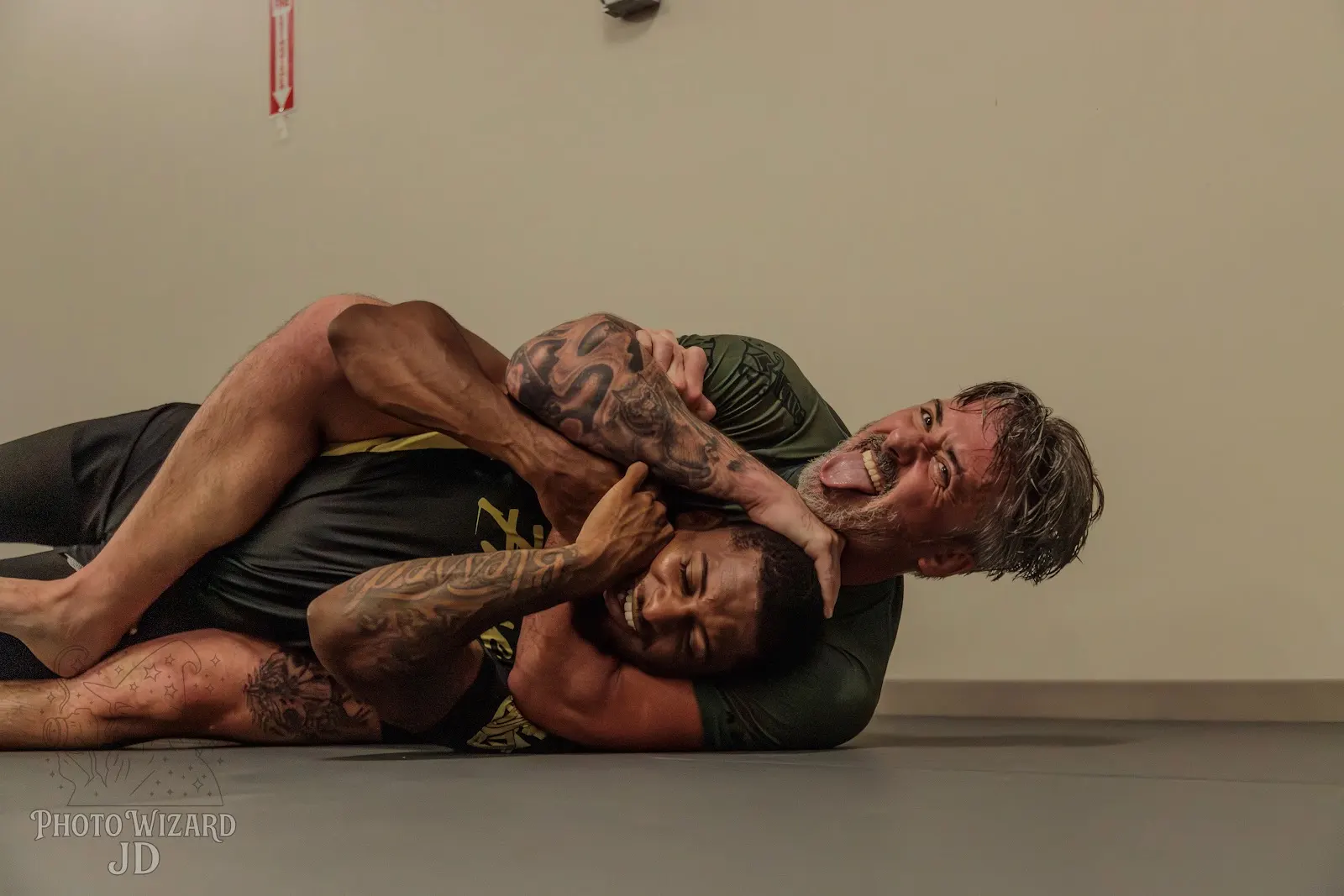 Training partners practicing back control on the mats